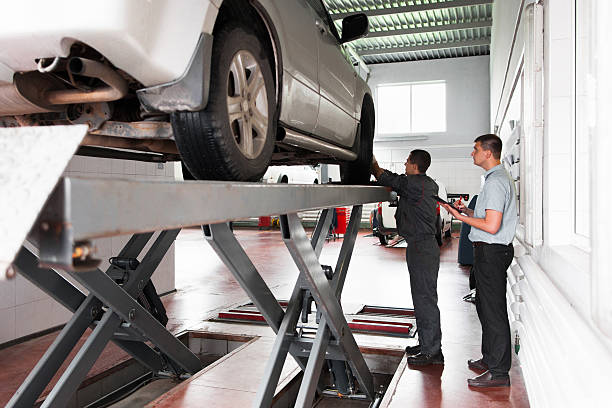 Car suspension system inspection at workshop. Professional diagnostics of automobile, lifted on elevator at modern service, warranty auto examination
